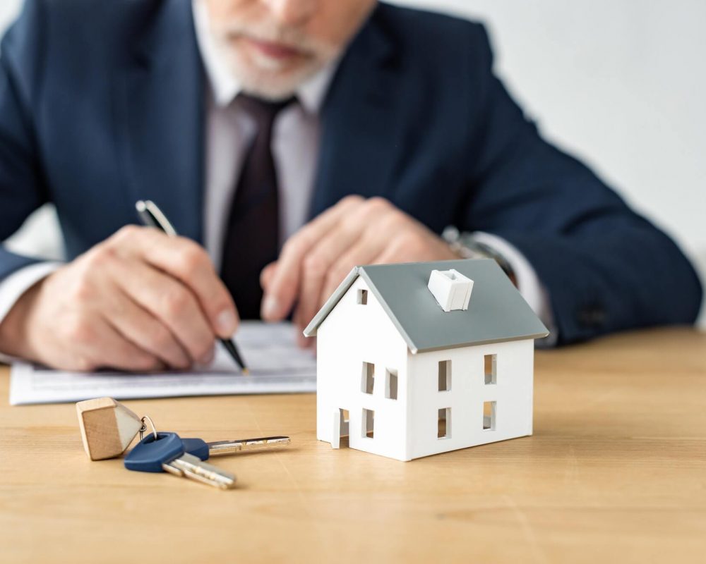 selective-focus-of-house-model-near-keys-and-house-dealer.jpg